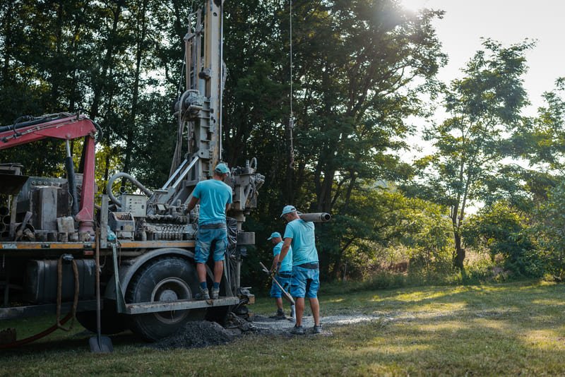 A variety of drilling rigs including rotary, percussion, and auger types at a construction site