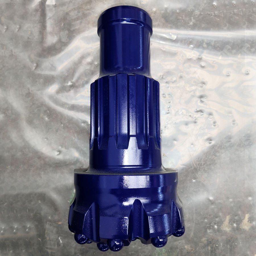 Close-up of a Down-the-Hole drill bit next to a button bit in a mining environment
