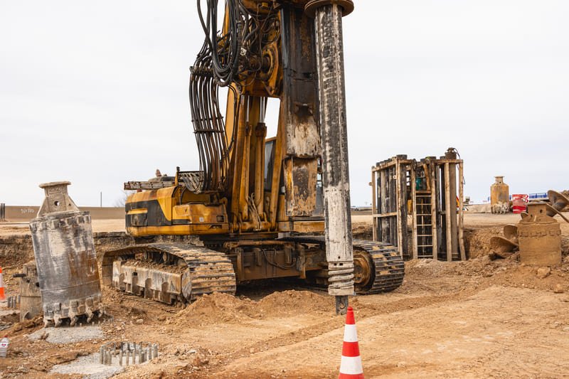 A construction site showing two drilling methods side by side