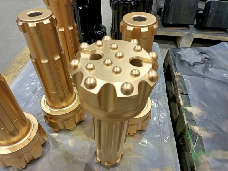 Close-up of DTH drill bits on a wooden workbench