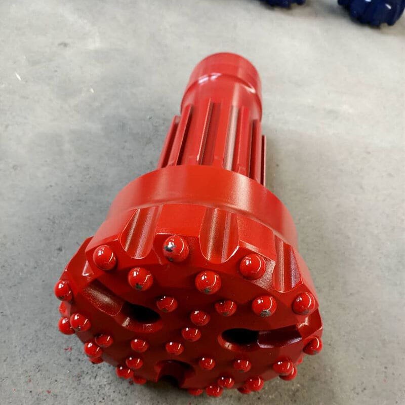 Close-up of a Down-the-Hole drill bit on rocky surface
