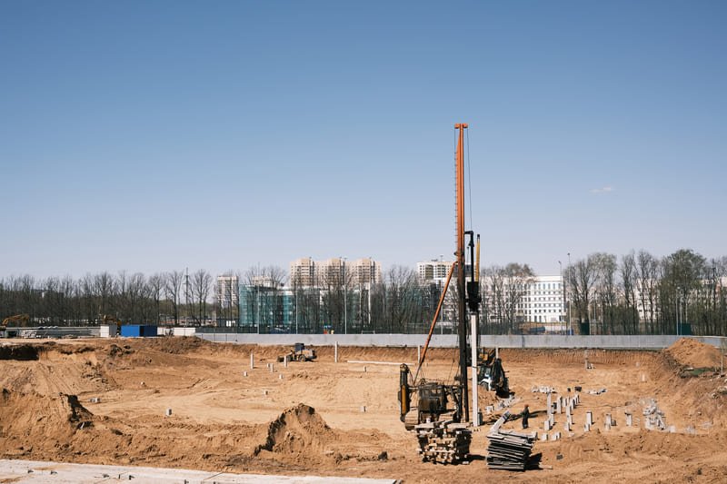 A DTH drill bit drilling into hard rock with dust flying