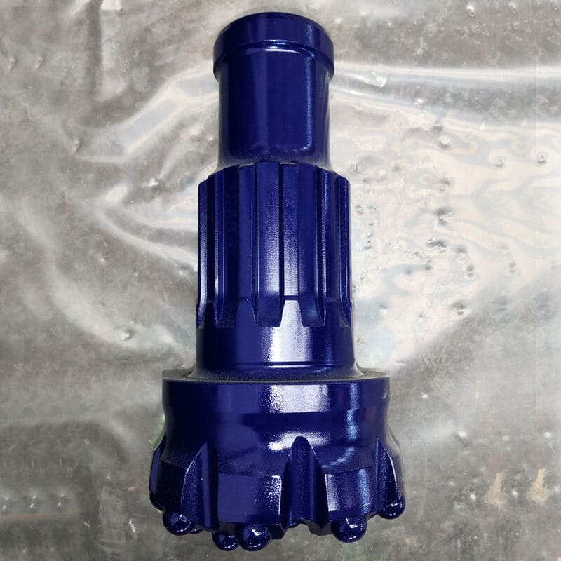 Close-up of a Down-The-Hole drill bit on rocky surface