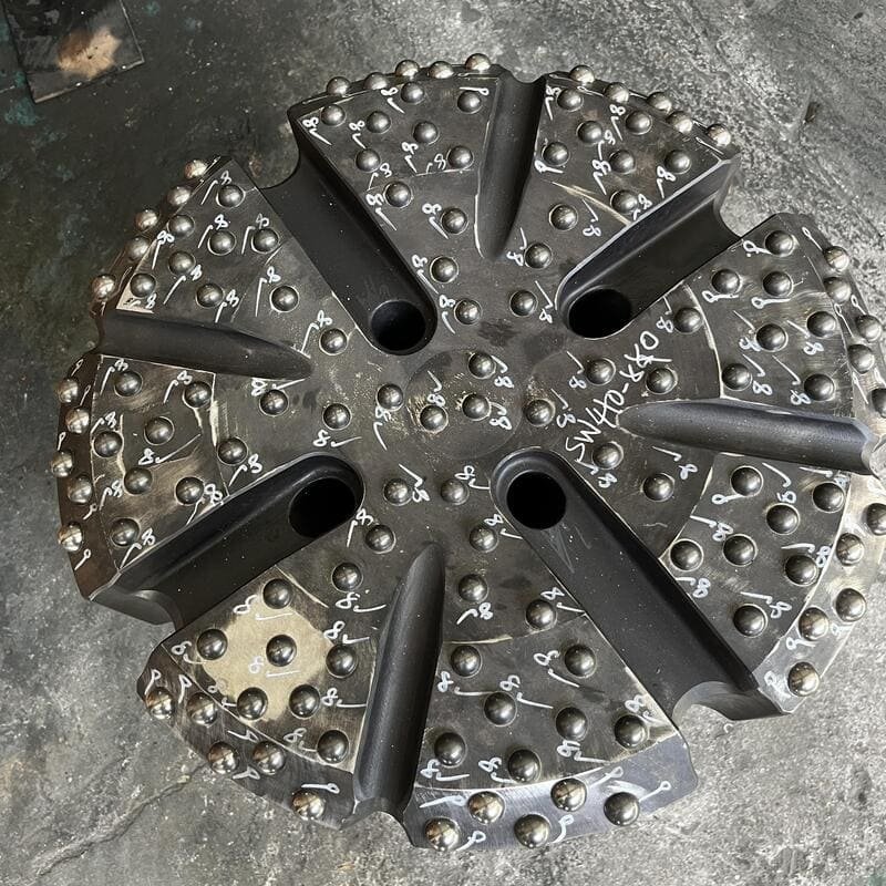 A close-up of worn-out drill bits with visible wear and dullness