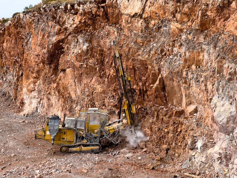 DTH drill bit drilling into hard rock