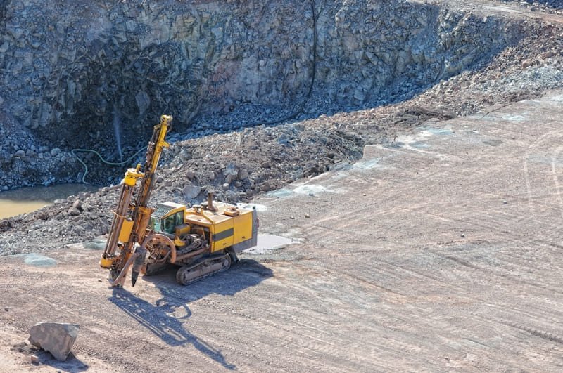Construction site with heavy machinery and workers drilling