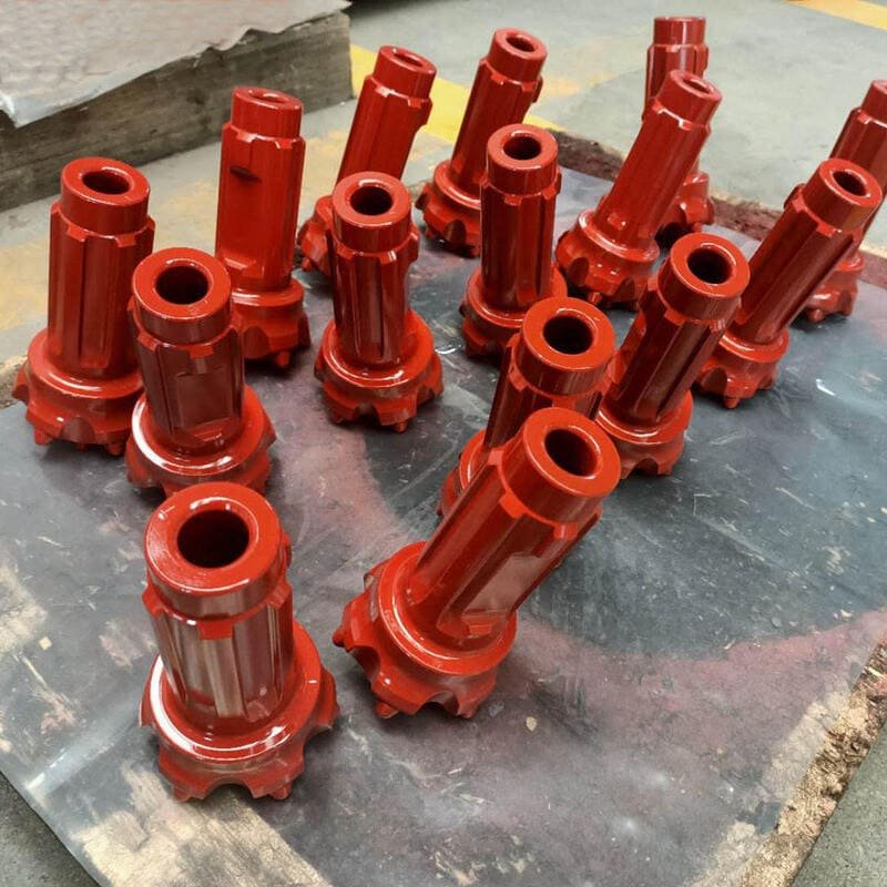 Assorted DTH drill bits on a workbench in a workshop