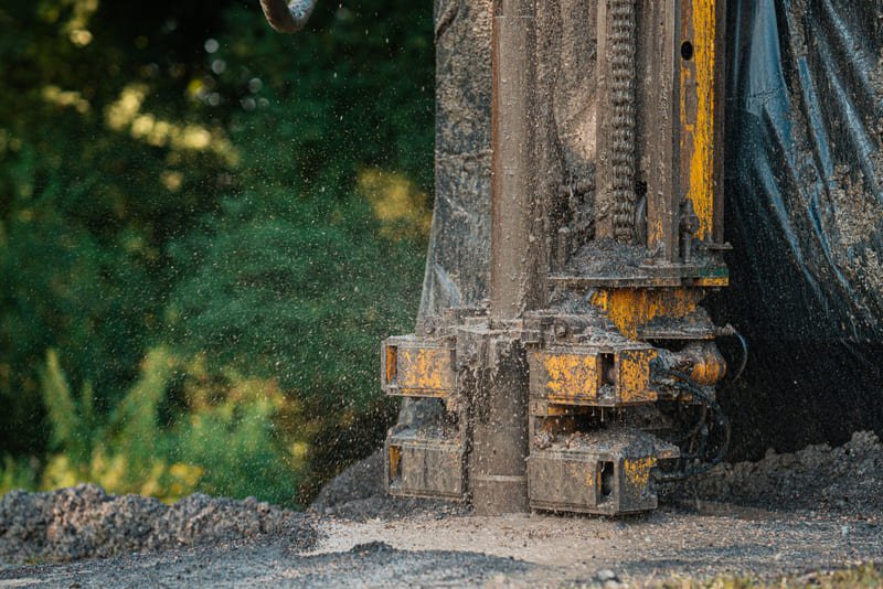 Water well drilling rig with visible components like derrick, rotary table, drill string, and mud pump.