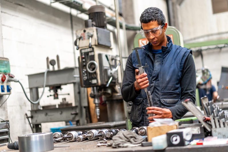Technician cleaning a DTH hammer in a workshop