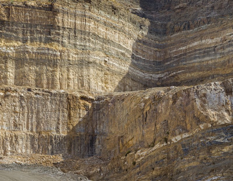 A close-up view of consolidated sediments showcasing various textures and colors, illustrating geological processes over time.