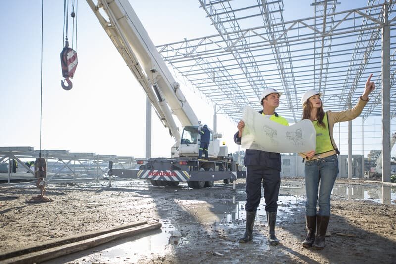 A bustling construction site with workers, machinery, and building materials, showcasing the progress of a new structure.