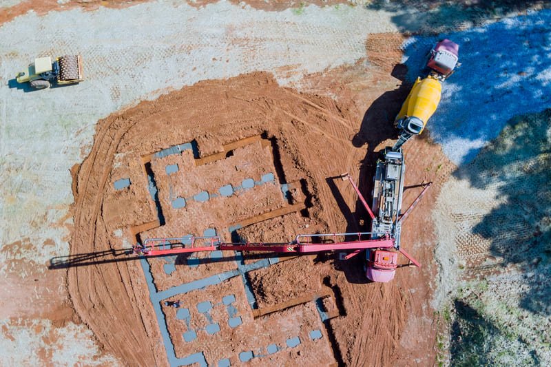 A construction site showcasing foundation drilling equipment in action, creating deep holes for building foundations.
