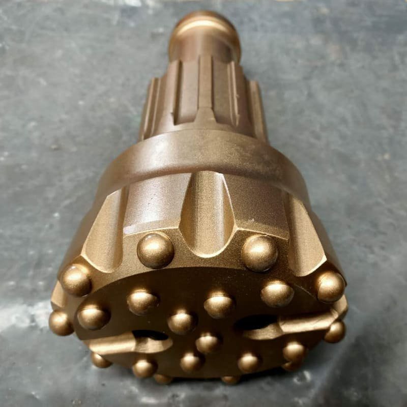 Close-up of a customized DTH drill bit on rocky surface