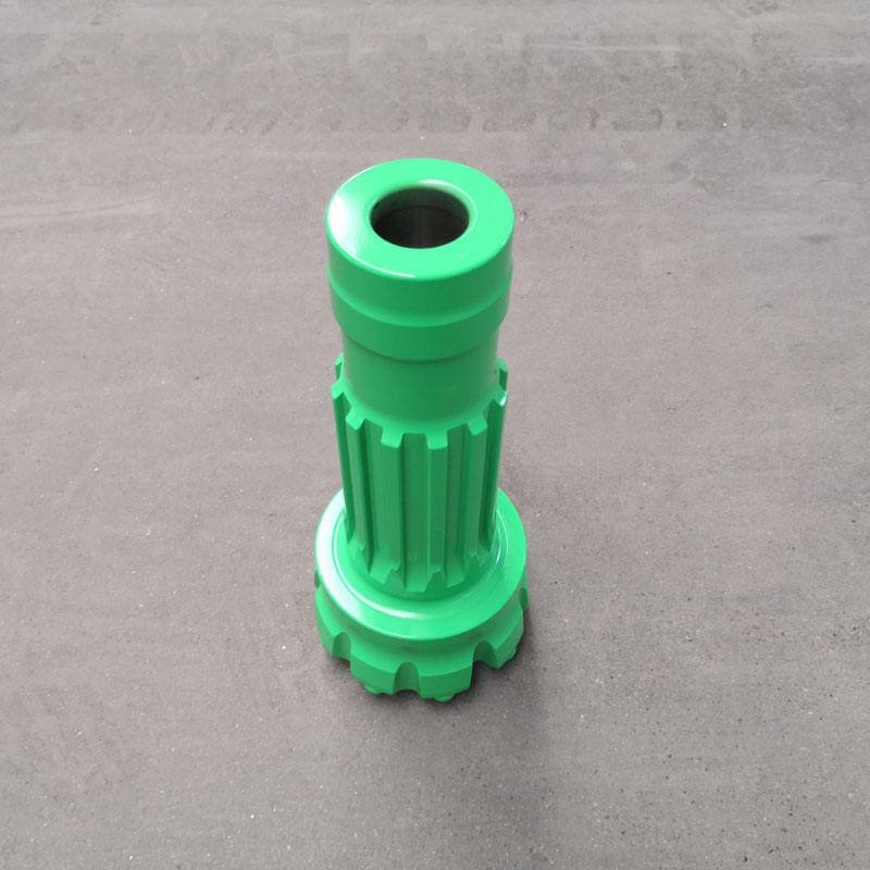 Close-up of a green DTH drill bit, showcasing its intricate design and sharp cutting edges for efficient drilling.