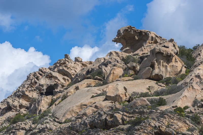 A rugged landscape featuring towering hard rock formations, showcasing intricate textures and natural beauty under a clear sky.