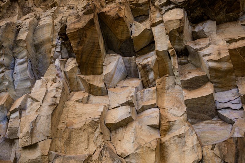 A close-up of a hard rock surface showing intricate textures and patterns, highlighting its geological features.