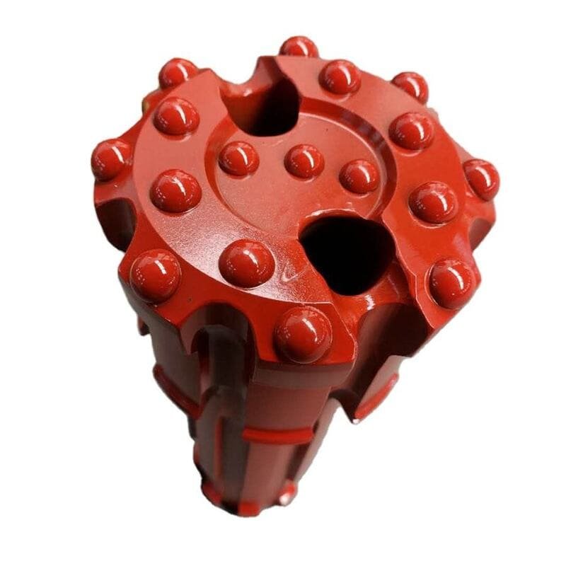 Close-up of a DTH drill bit on rocky terrain