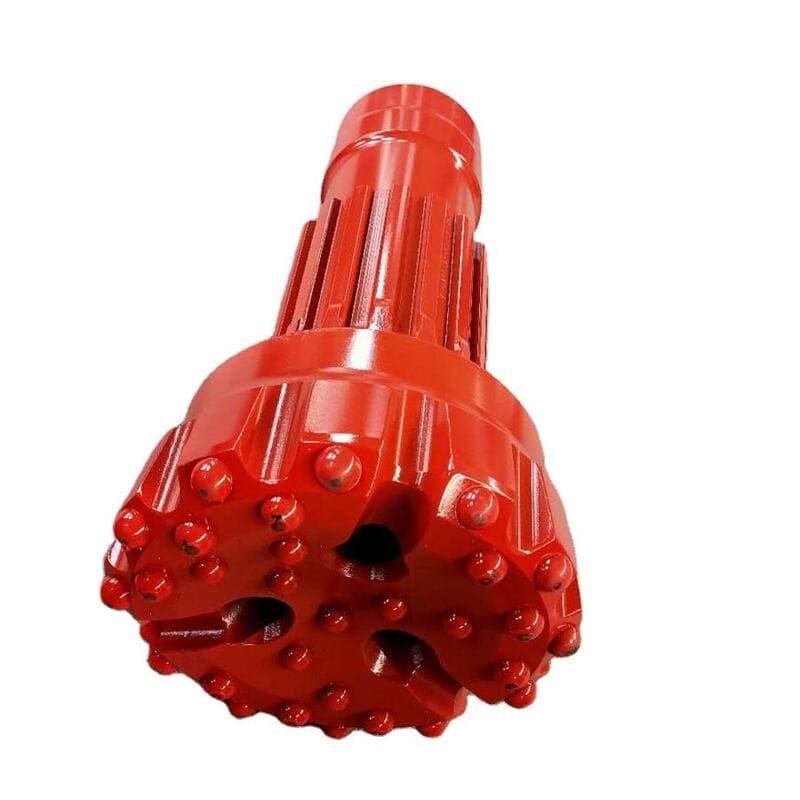 Close-up of a DTH drill bit on rocky terrain