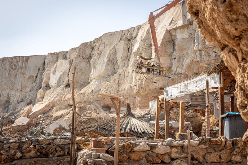 A quarry drilling site featuring heavy machinery and workers engaged in extracting stone from the earth.