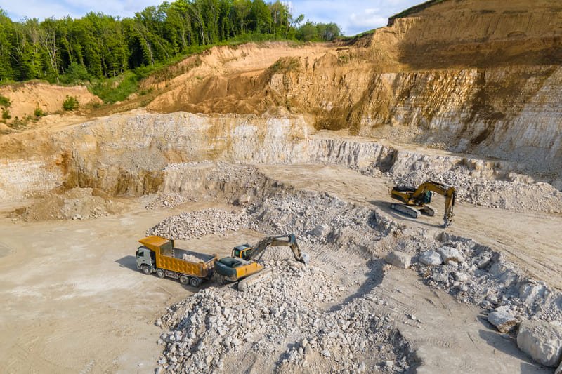 A stone quarry showcasing large rock formations and machinery used for extracting stone materials from the earth.