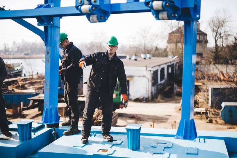 A technician performing a well installation, surrounded by equipment and tools in a rural setting.