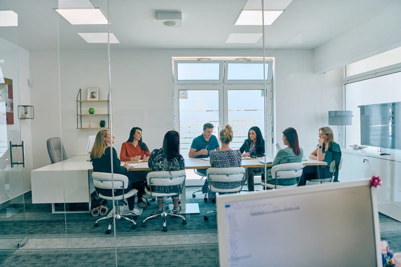 A group of professionals engaged in discussion during an official supplier meeting, showcasing collaboration and partnership.
